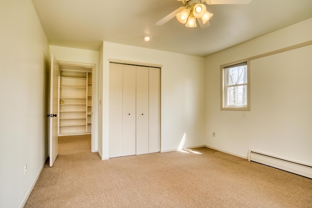 unfurnished bedroom featuring ceiling fan, light colored carpet, baseboard heating, baseboards, and a closet