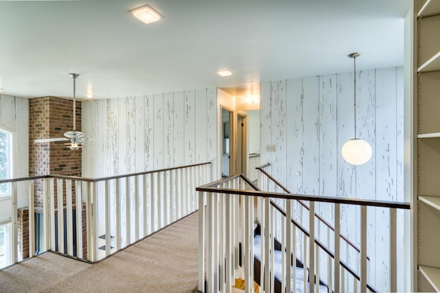 hallway featuring an upstairs landing and carpet