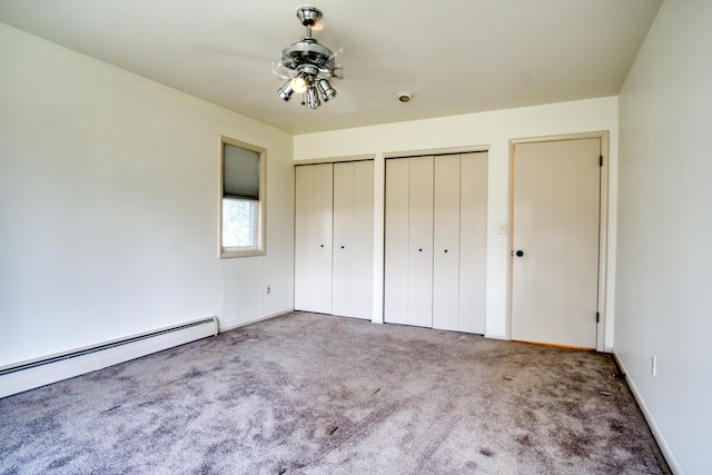 unfurnished bedroom with baseboards, carpet, two closets, and baseboard heating