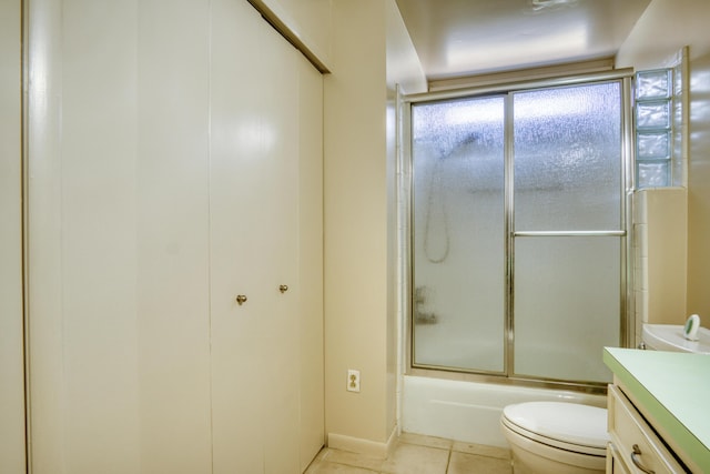 full bath with vanity, tile patterned flooring, bath / shower combo with glass door, and toilet