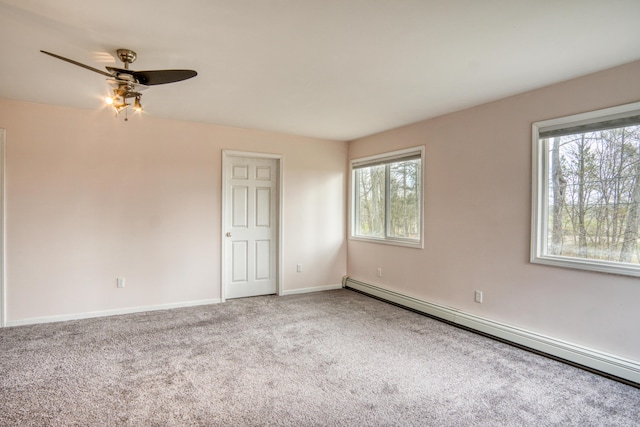 carpeted spare room featuring plenty of natural light, baseboards, a baseboard radiator, and a ceiling fan