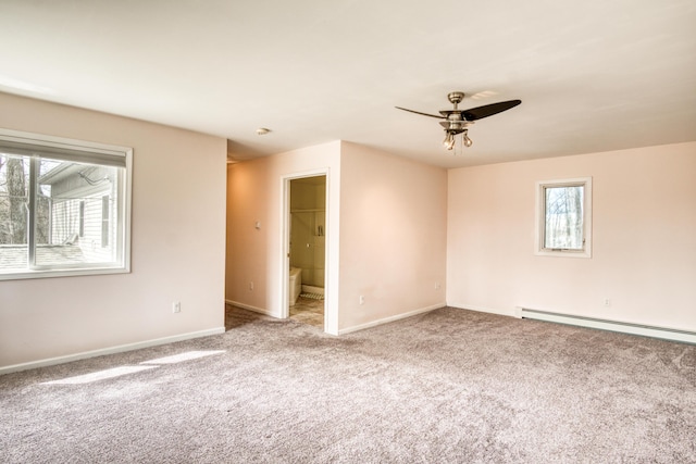 carpeted spare room with baseboards, baseboard heating, a ceiling fan, and a healthy amount of sunlight