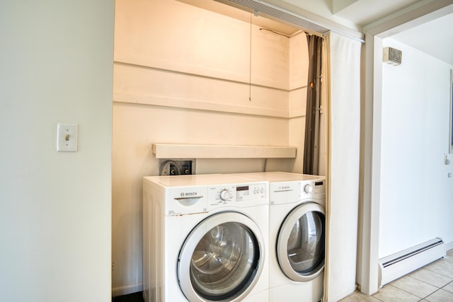laundry area featuring baseboard heating, washing machine and dryer, light tile patterned flooring, and laundry area