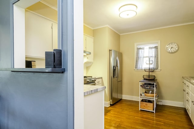 kitchen with crown molding, light countertops, stainless steel appliances, white cabinetry, and dark wood-style floors