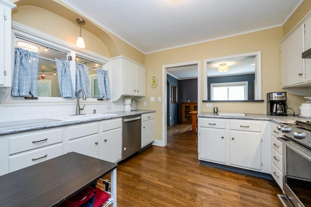 kitchen with a sink, appliances with stainless steel finishes, dark wood finished floors, and white cabinetry