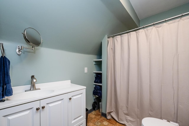 bathroom featuring vanity, stone finish floor, and toilet