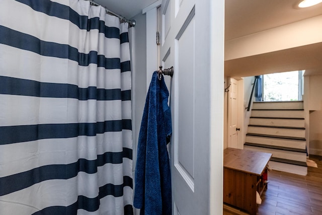 full bathroom with curtained shower and wood finished floors
