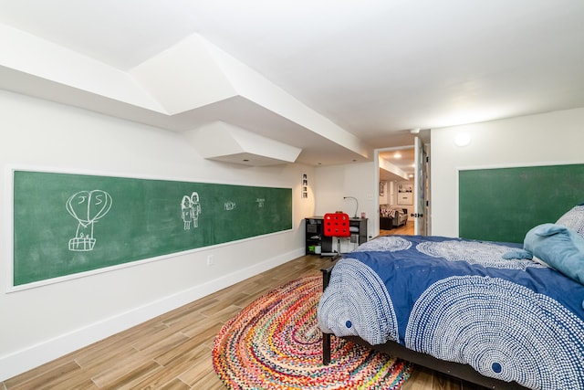 bedroom featuring baseboards and wood finished floors