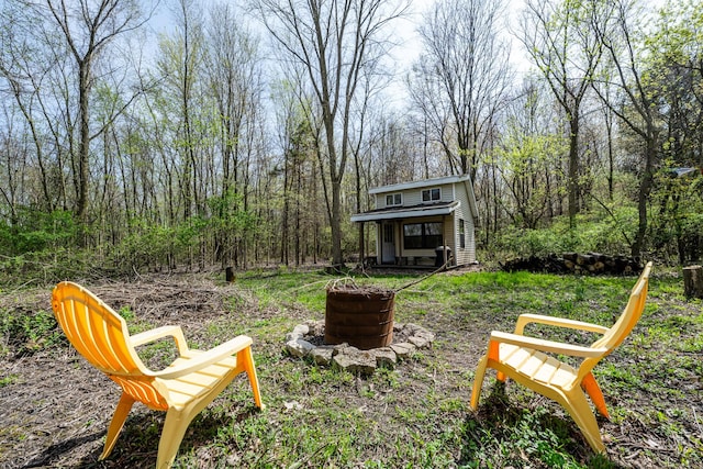 view of yard with an outdoor structure and a fire pit