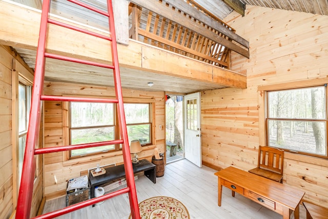 interior space with wooden walls, high vaulted ceiling, and wood-type flooring