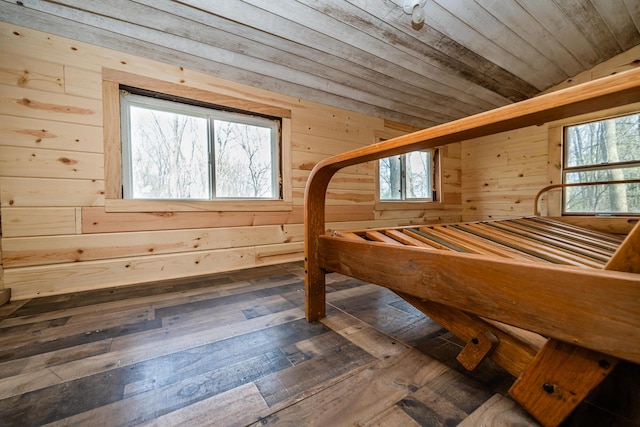 unfurnished bedroom featuring wooden ceiling, wood walls, multiple windows, and lofted ceiling