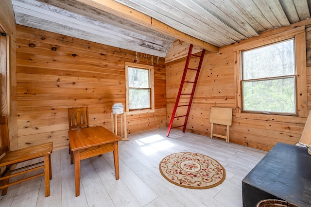 living area featuring wood walls, lofted ceiling, wood ceiling, and light wood-style flooring