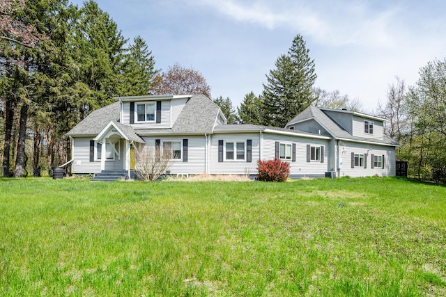 view of front of home with central AC unit, a front lawn, and roof with shingles