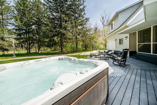 wooden deck with an outdoor living space, a garage, and a hot tub