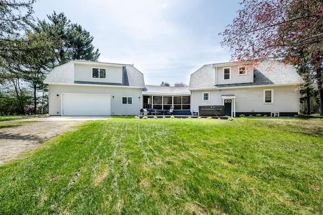 rear view of property with a sunroom, a lawn, roof with shingles, and driveway