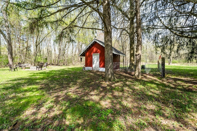 view of yard featuring a storage shed, an outbuilding, and an outdoor fire pit