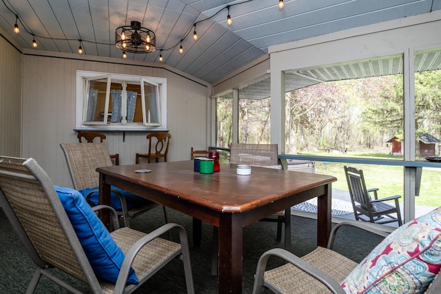 sunroom featuring rail lighting and outdoor dining area