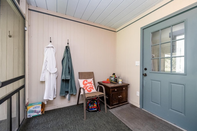 mudroom with carpet flooring, wood walls, and wood ceiling