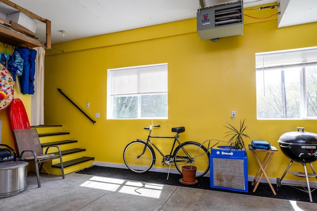interior space featuring a healthy amount of sunlight, baseboards, concrete floors, and a heating unit