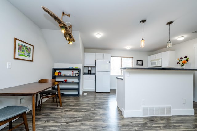 kitchen featuring dark countertops, white appliances, white cabinetry, and visible vents
