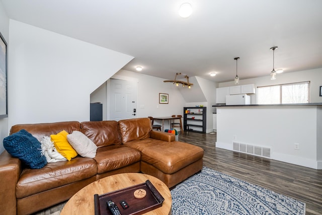 living room with baseboards, wood finished floors, and visible vents