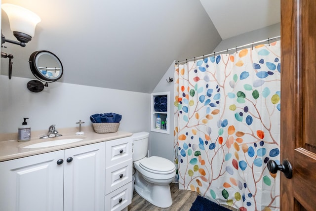 full bath featuring toilet, wood finished floors, lofted ceiling, and vanity