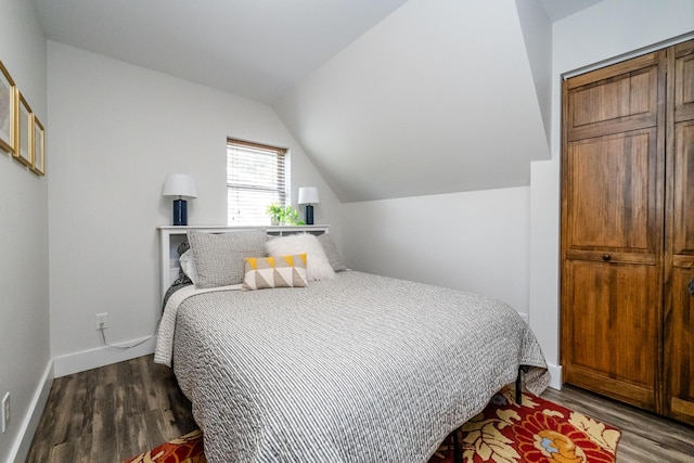 bedroom featuring baseboards, dark wood finished floors, and lofted ceiling