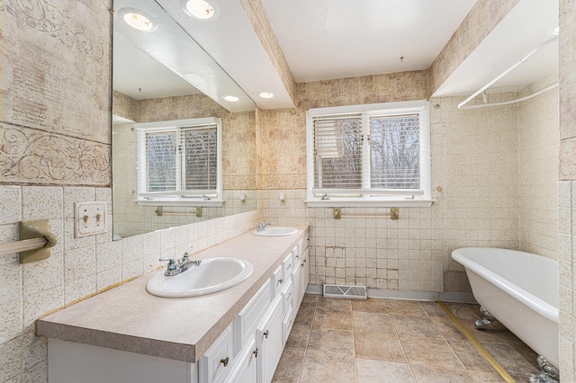 10145 W Kl Ave, Kalamazoo, MI 49009 - full bath featuring a sink, tile walls, double vanity, and a freestanding bath