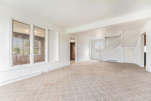 10145 W Kl Ave, Kalamazoo, MI 49009 - unfurnished living room featuring visible vents, carpet floors, stairs, baseboards, and a baseboard heating unit