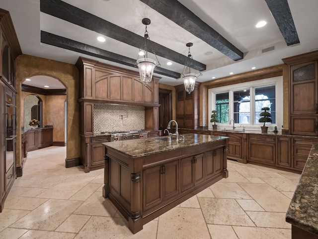 26565 Scenic, Franklin, MI 48025 - kitchen with a sink, a kitchen island with sink, arched walkways, dark stone countertops, and stone tile floors