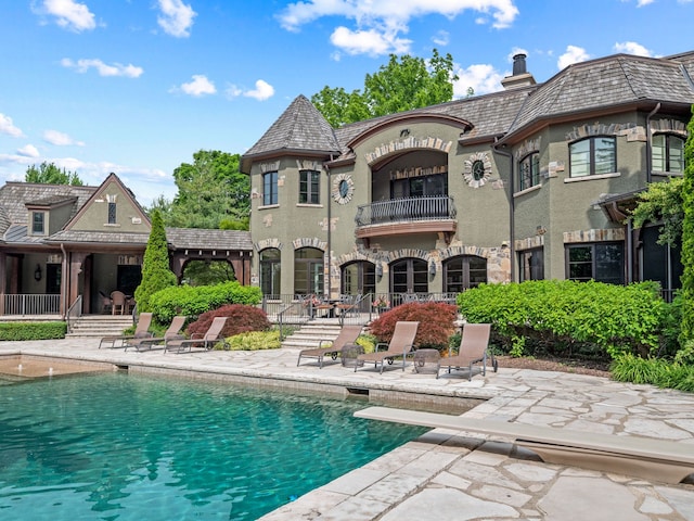26565 Scenic, Franklin, MI 48025 - back of house featuring a high end roof, stucco siding, an outdoor pool, a patio area, and a balcony