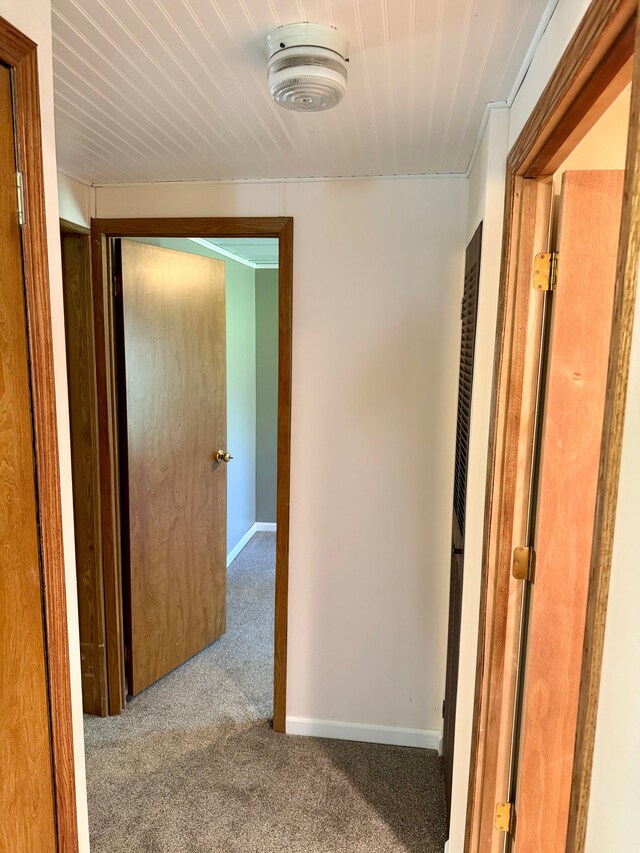 corridor with carpet floors and baseboards