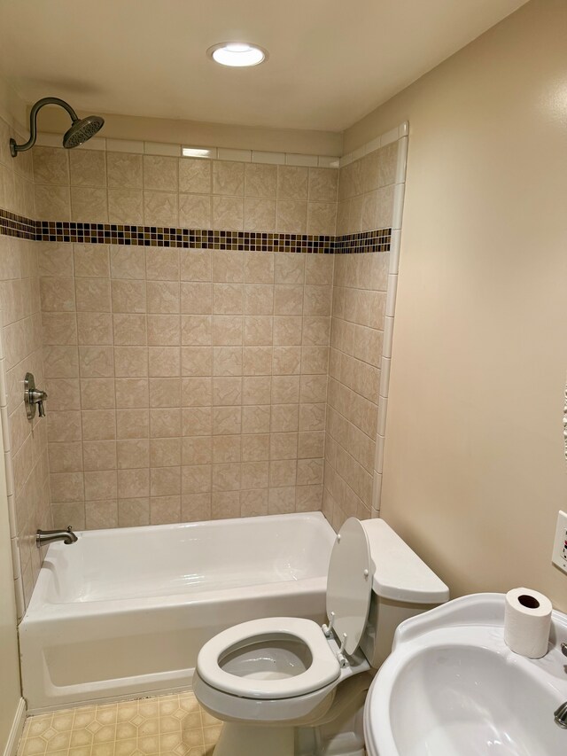 bathroom featuring recessed lighting, bathing tub / shower combination, toilet, and a sink