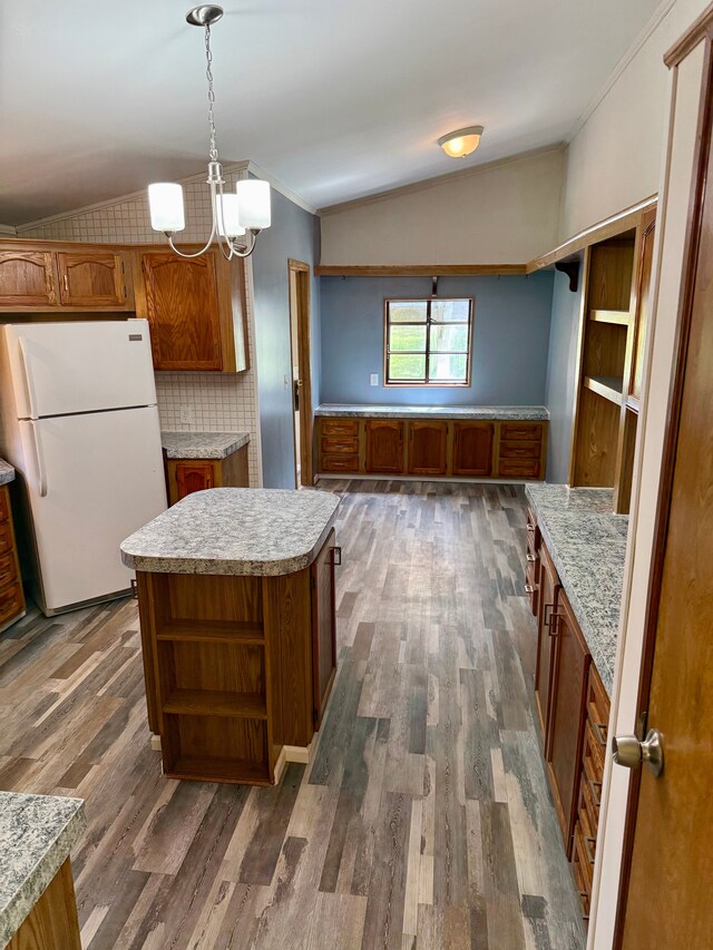 kitchen with crown molding, freestanding refrigerator, open shelves, brown cabinets, and vaulted ceiling
