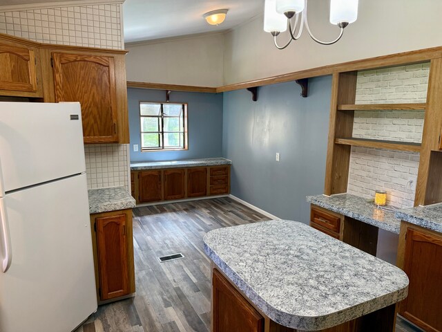 kitchen featuring tasteful backsplash, open shelves, light countertops, freestanding refrigerator, and dark wood-style floors