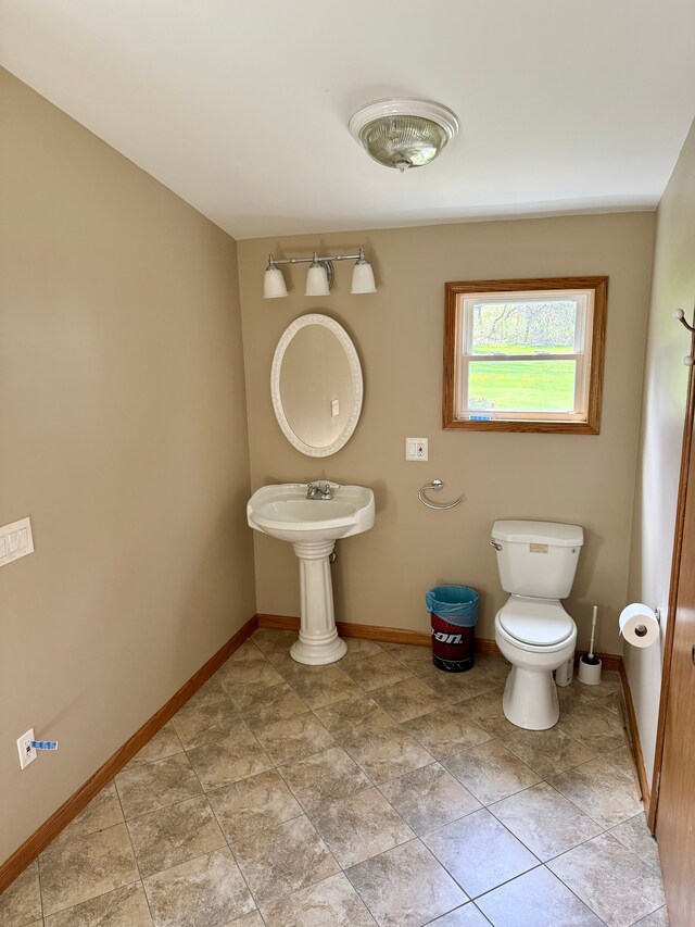 bathroom with baseboards and toilet