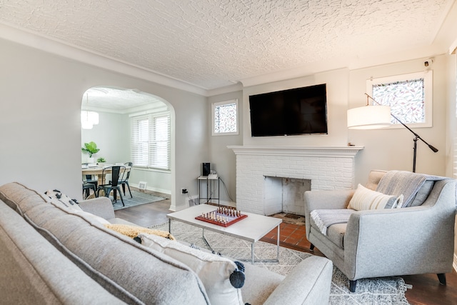 17215 Warrington Dr, Detroit, MI 48221 - living area with ornamental molding, a brick fireplace, baseboards, a textured ceiling, and arched walkways