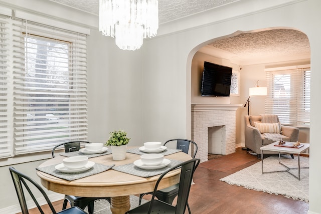 17215 Warrington Dr, Detroit, MI 48221 - dining space featuring arched walkways, a textured ceiling, and wood finished floors