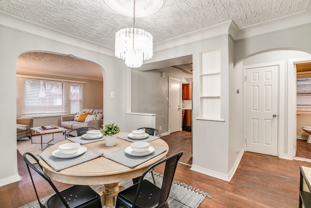 17215 Warrington Dr, Detroit, MI 48221 - dining space with a notable chandelier, arched walkways, a textured ceiling, baseboards, and wood finished floors