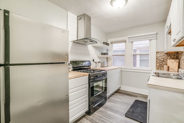 17215 Warrington Dr, Detroit, MI 48221 - kitchen with freestanding refrigerator, light countertops, wall chimney exhaust hood, a sink, and gas stove