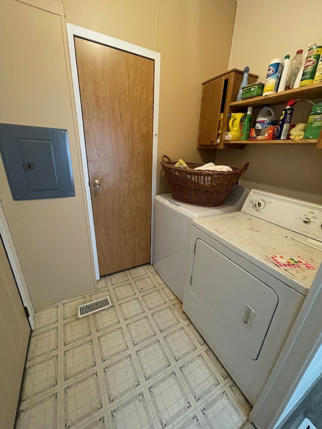 laundry room with visible vents, washer and dryer, light floors, electric panel, and cabinet space