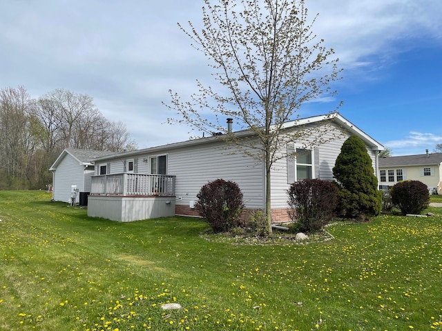 back of property with a lawn and a deck
