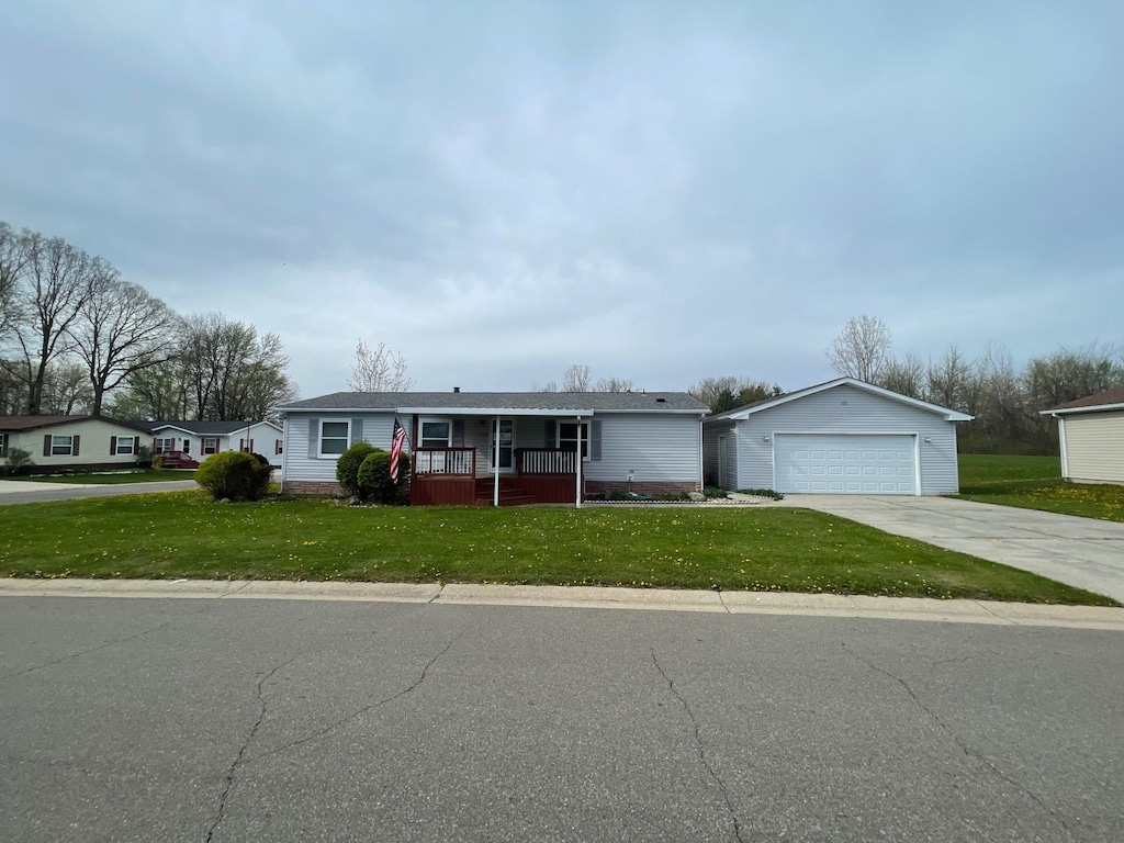 11383 Harbor Cv, Fenton, MI 48430 - single story home with a porch, a garage, a front yard, and an outdoor structure