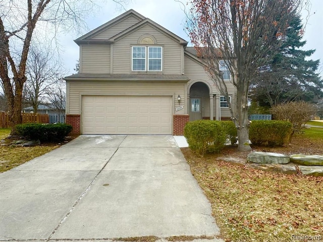 traditional-style home with concrete driveway, brick siding, fence, and a garage