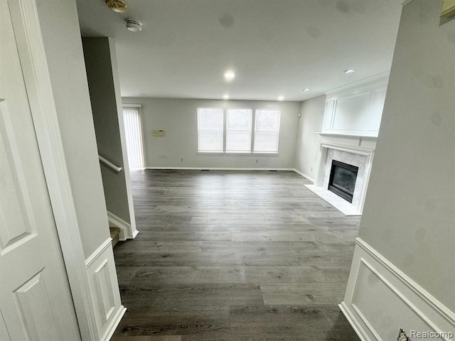 unfurnished living room with recessed lighting, a fireplace, dark wood-style flooring, and stairs