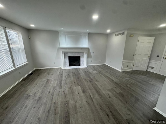unfurnished living room with recessed lighting, a fireplace, dark wood-style flooring, and visible vents