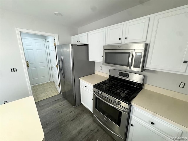 kitchen featuring light countertops, white cabinets, stainless steel appliances, and wood finished floors