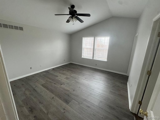 unfurnished bedroom with baseboards, visible vents, dark wood-style floors, and lofted ceiling