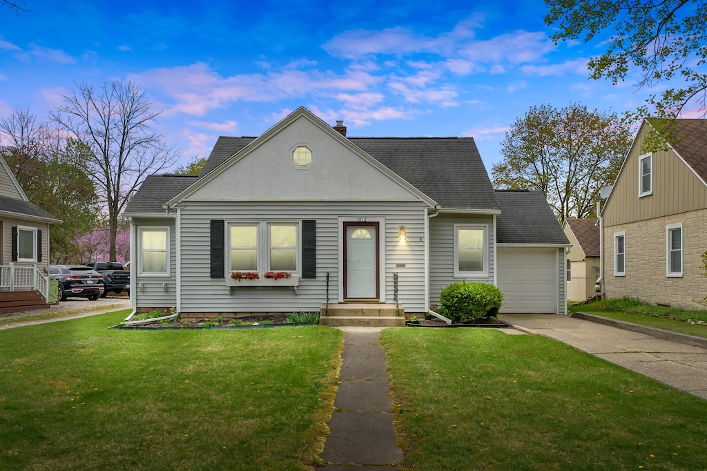 view of front of property featuring a chimney, roof with shingles, a front yard, and concrete driveway