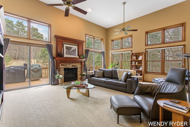 carpeted living room with ceiling fan, a high ceiling, and a fireplace
